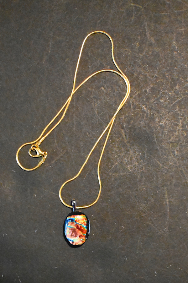 Fused dichroic glass basket shaped pendant on gold chain by Susan Mason