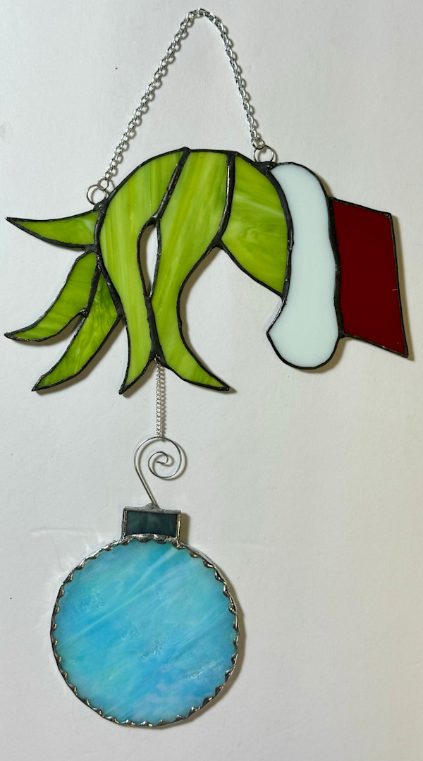 Grinch like hand with ornament stained glass by Jane D. Steelman
