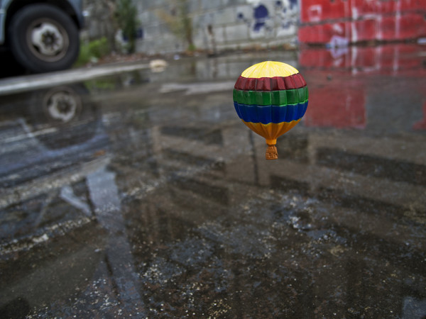 Inches Above Earth Series "Approximate Altitude 13.1 Inches " (Hot Air Balloon over Wet Street) by Michael Reese