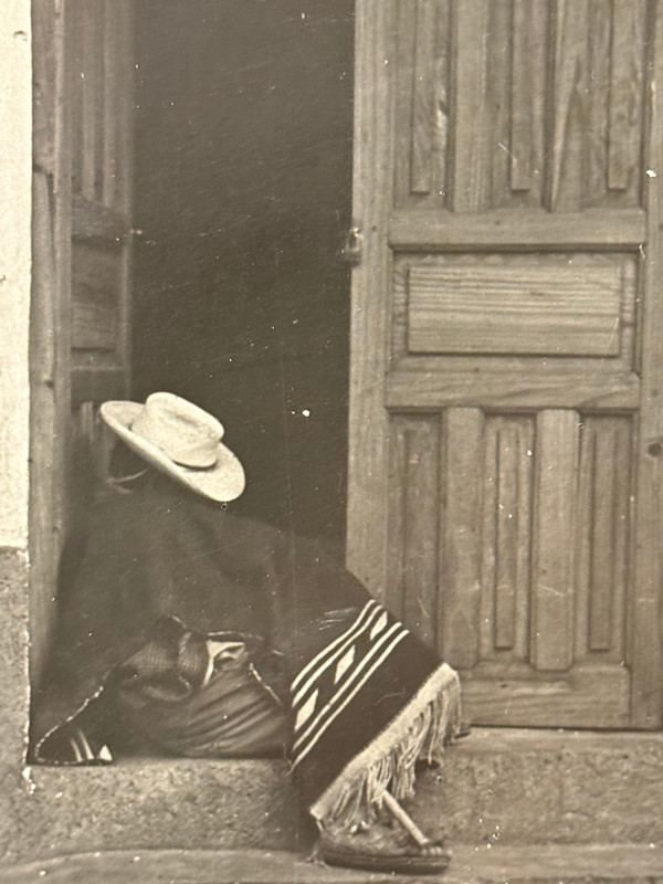 black and white photograph seated figure in a doorway