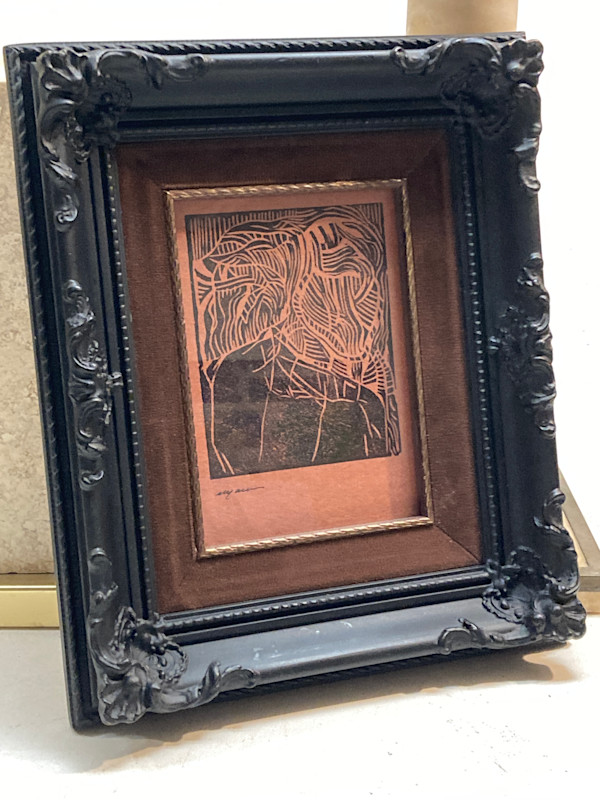 Framed woodcut print in ornate  black frame