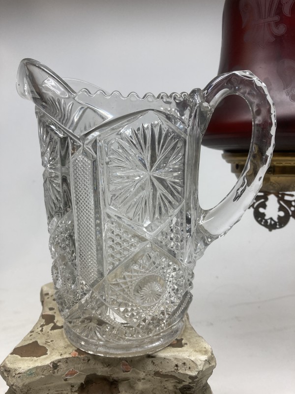 clear glass water pitcher with ornate pattern