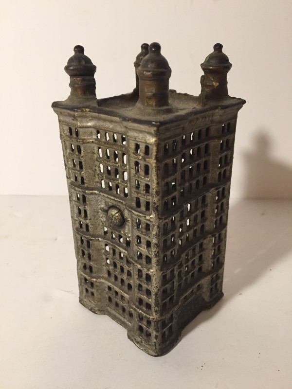 early iron penny bank in the shape of the Wrigley building