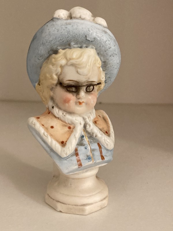 small bisque figure with glasses