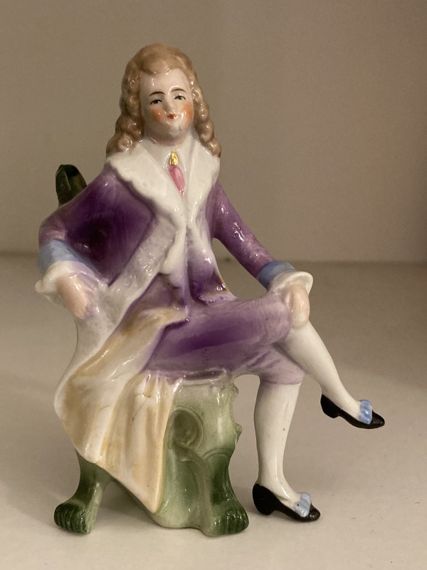 hand painted porcelain seated man in purple coat