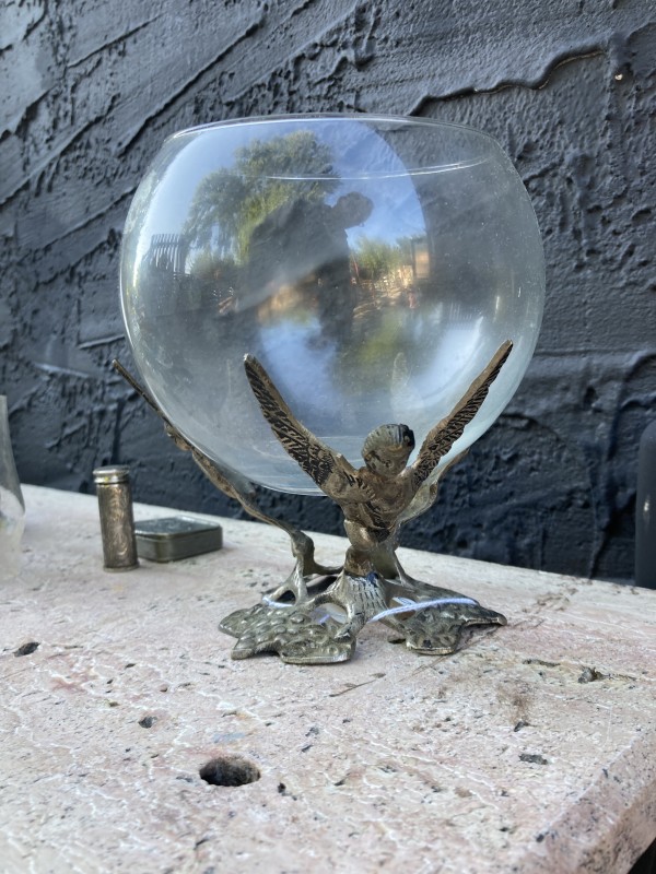 Winged metal figural base with glass bowl