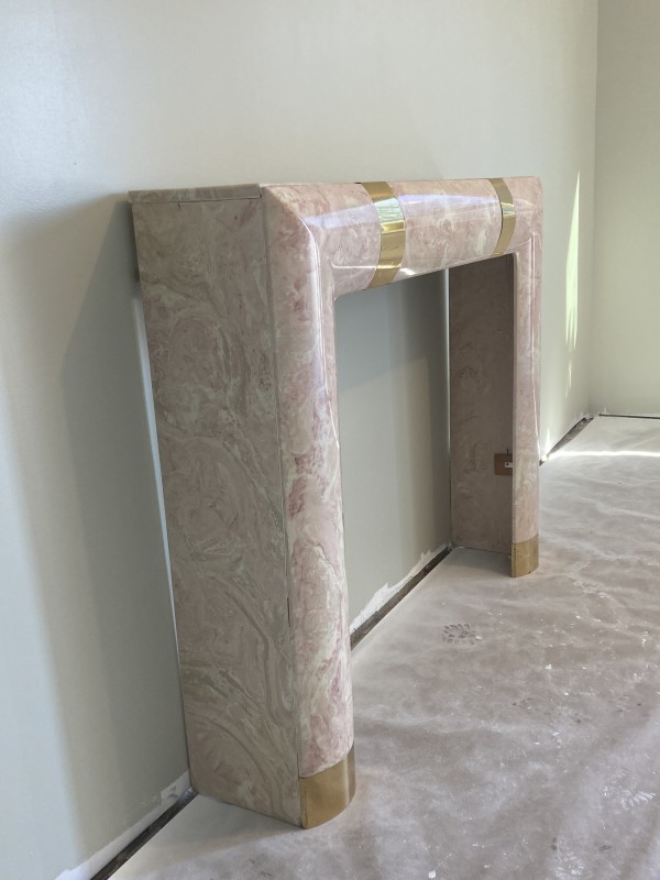 Pink marble post modern mantle with brass banding