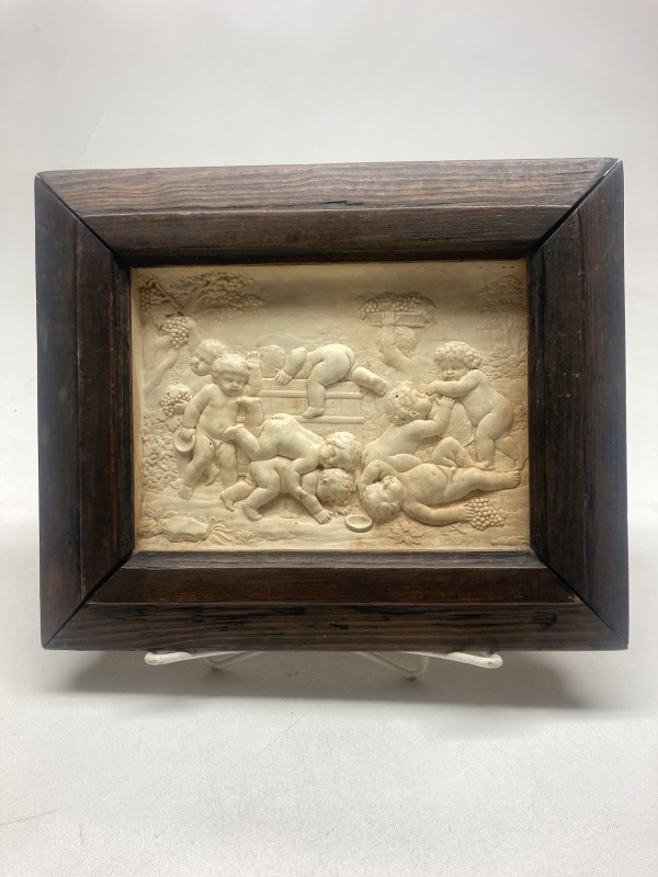 Framed relief of wine drinking cherubs