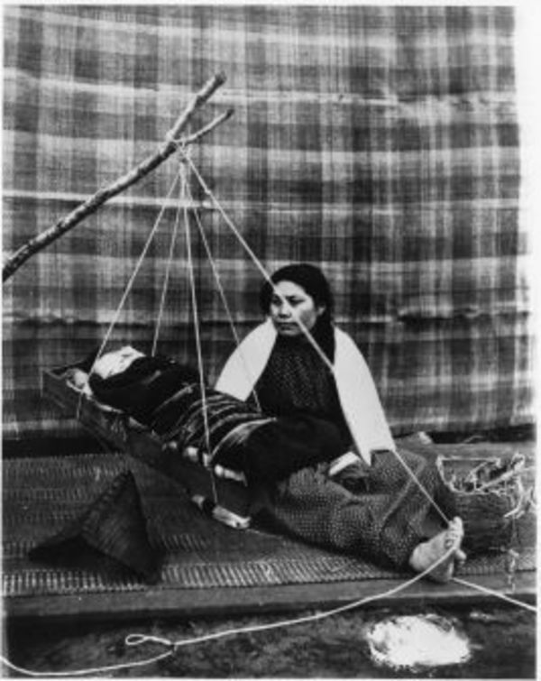 Makah mother rocking her baby by Charlotte Watts
