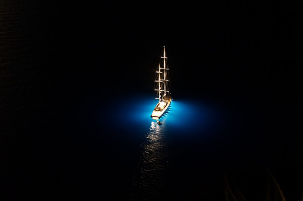 Sailboat at Night in Santorini by Lawrence Bridges