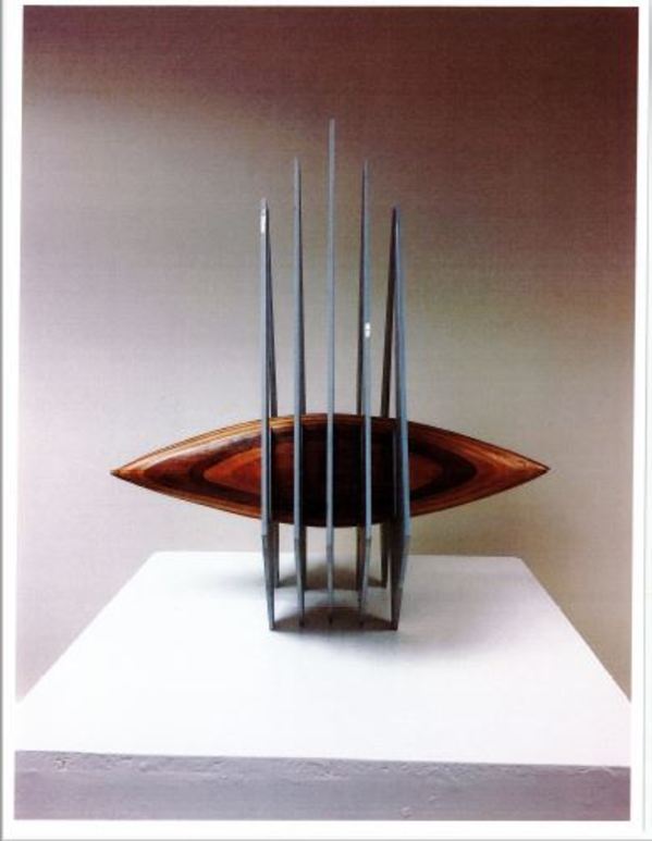 Metal triangle with boat-shaped wood insert by Sarah Yerkes