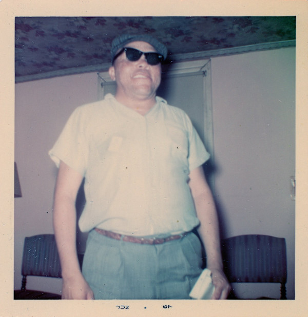 Man in glasses standing in pink room by Unknown