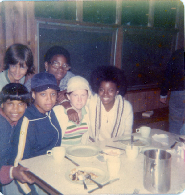 Young folks around restaurant table by Unknown