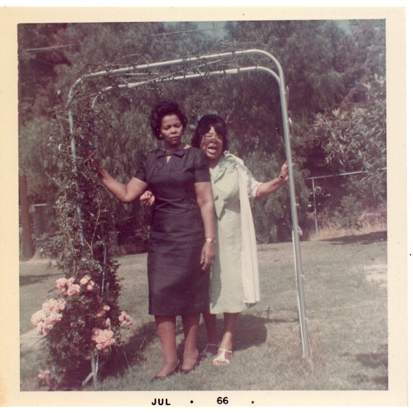 Lillie Estes Starks and friend standing under arbor by Unknown