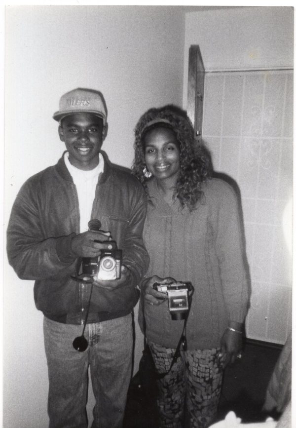 Woman & young man with cameras by Unknown