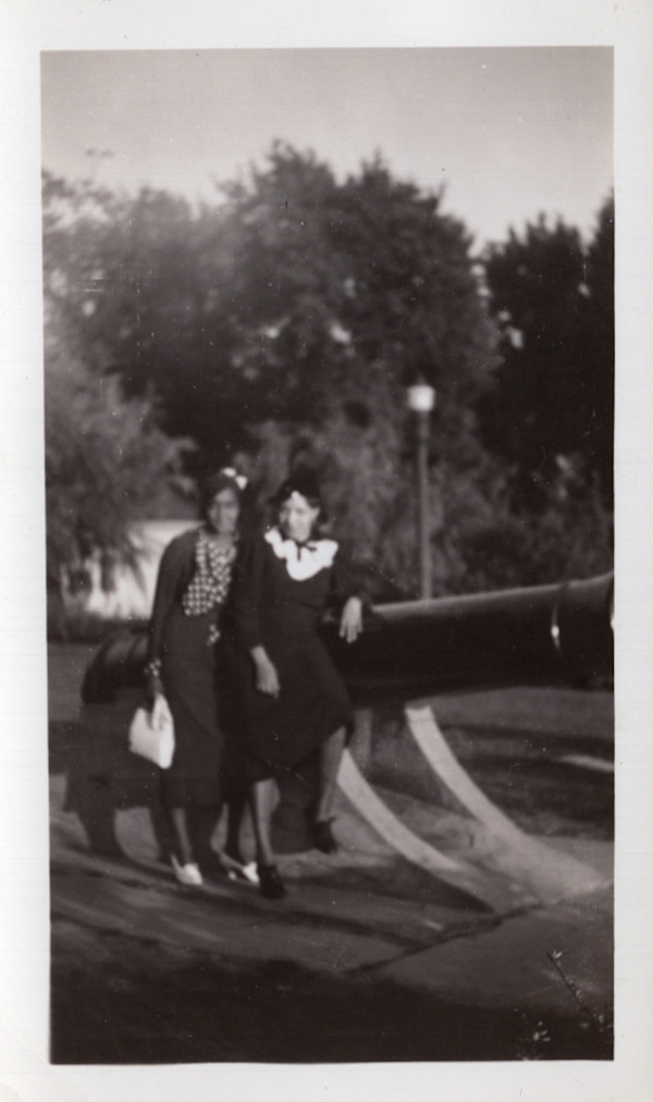 Two women posed next to cannon by Unknown