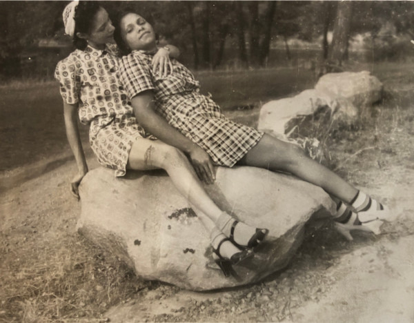 Two women lounging on rock by Unknown