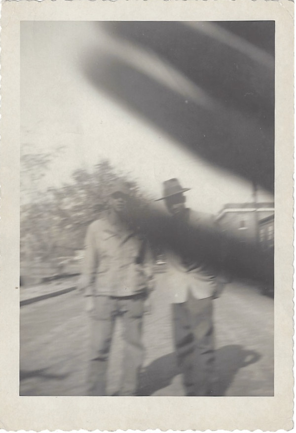 Two men behind hand in front of the camera by Unknown