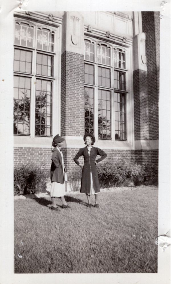 Two schoolgirls outside building by Unknown