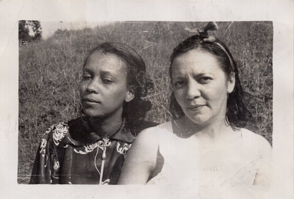Two women in the grass by the lakeshore by Unknown