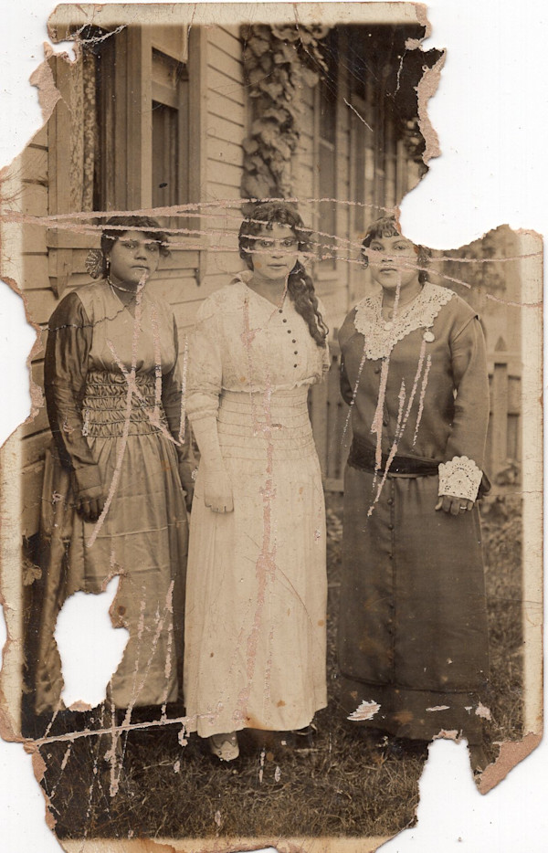 Three women in scratched photo by Unknown