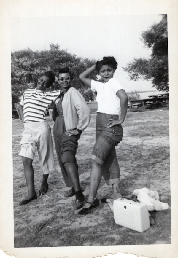 Three women posing showing legs by Unknown