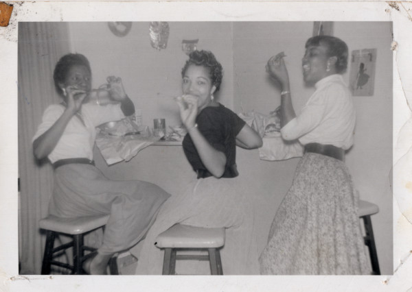 Three women eating at bar by Unknown