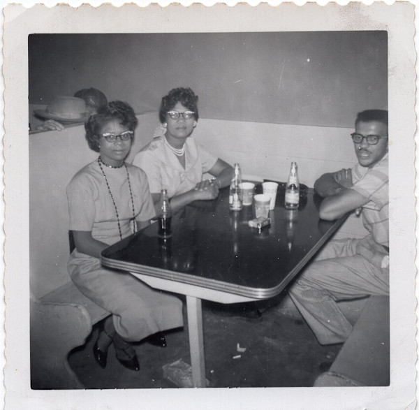 Two women & man in restaurant booth by Unknown