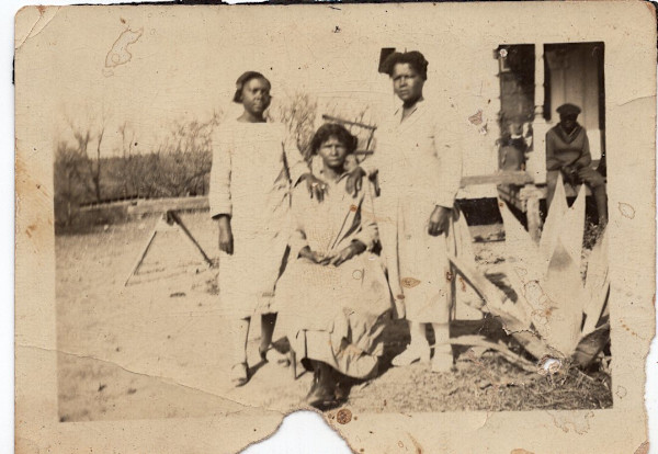 Three women posing by large succulent by Unknown