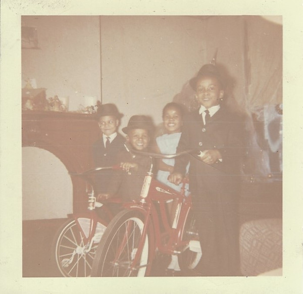Four boys in hats with bikes by Unknown