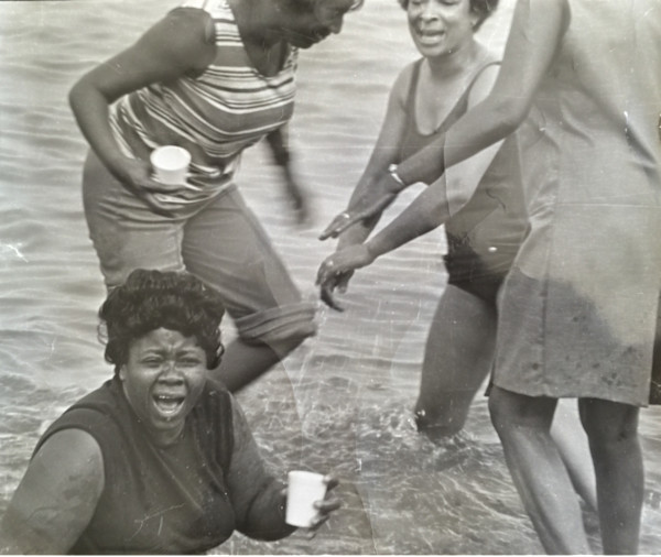 Four women frolicking in water by Unknown