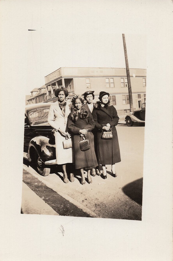 Four women standing in front of automobile by Unknown