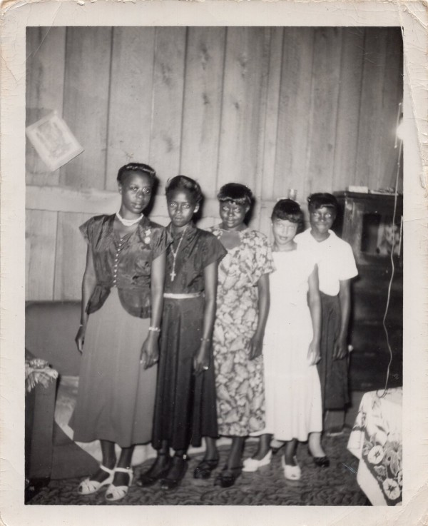 Five women standing in formation in paneled room by Unknown