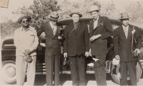 5 men with cameras standing by car by Unknown