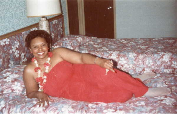 Lady in red wearing lei and holding key by Unknown