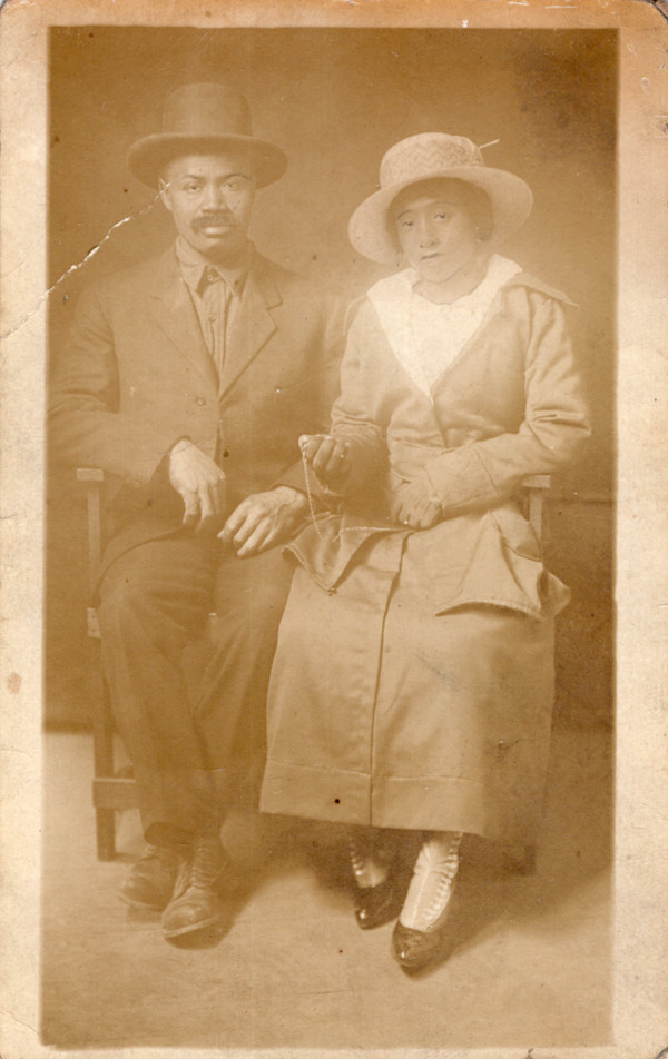 Seated couple with woman holding pocket watch and creepy retouching by Unknown