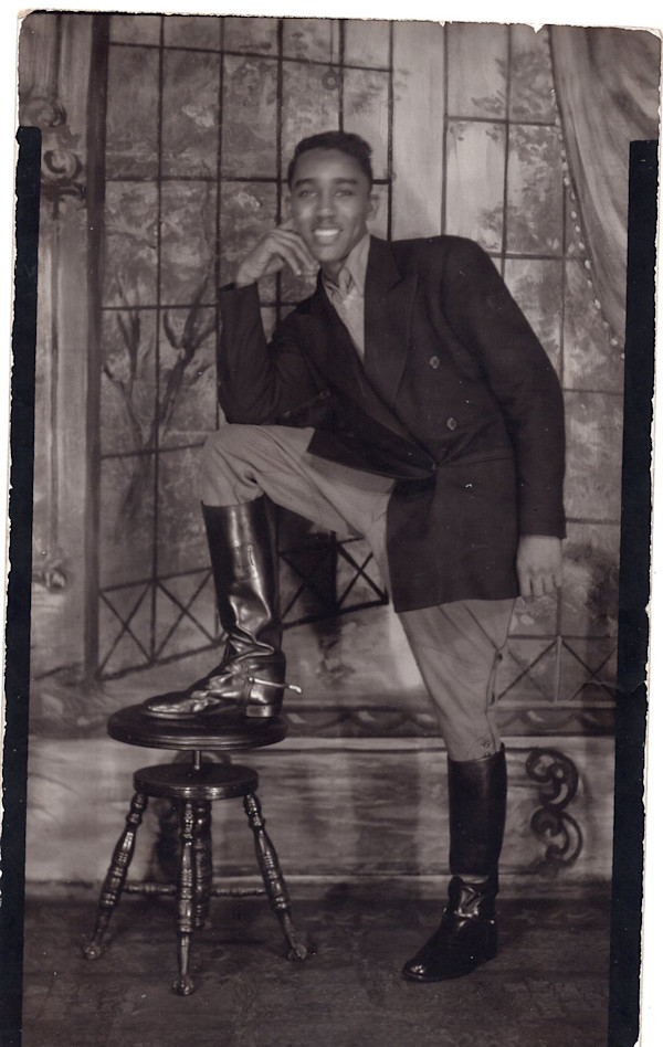 Studio portrait of young man in riding boots; leg on stool by Unknown