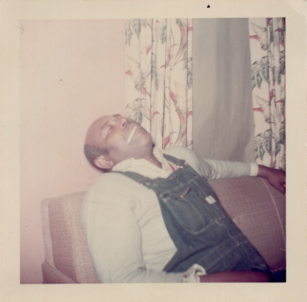 Hatless man asleep with cigarette in his mouth by Unknown