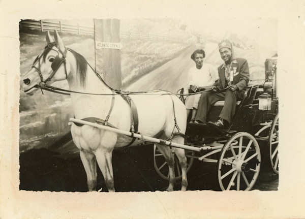 Jimmy + his wife in wagon with prop horse & Atlantic City sign by Unknown