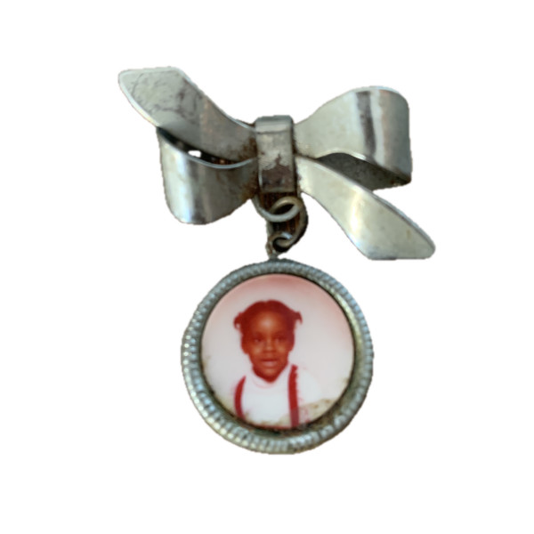 Silver bow photo brooch with photo of girl by Unknown