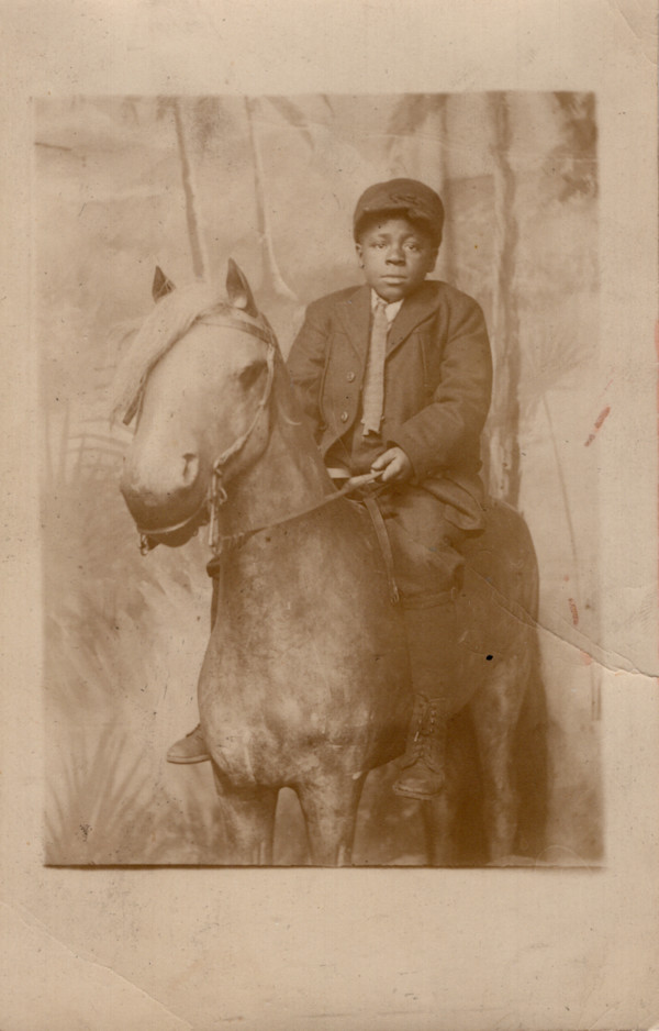 Boy on prop horse by Unknown