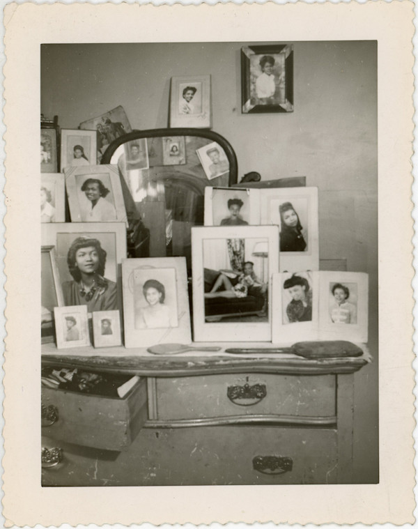 Vanity filled with framed photographs by Unknown