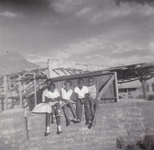 Children sitting on wall by Unknown