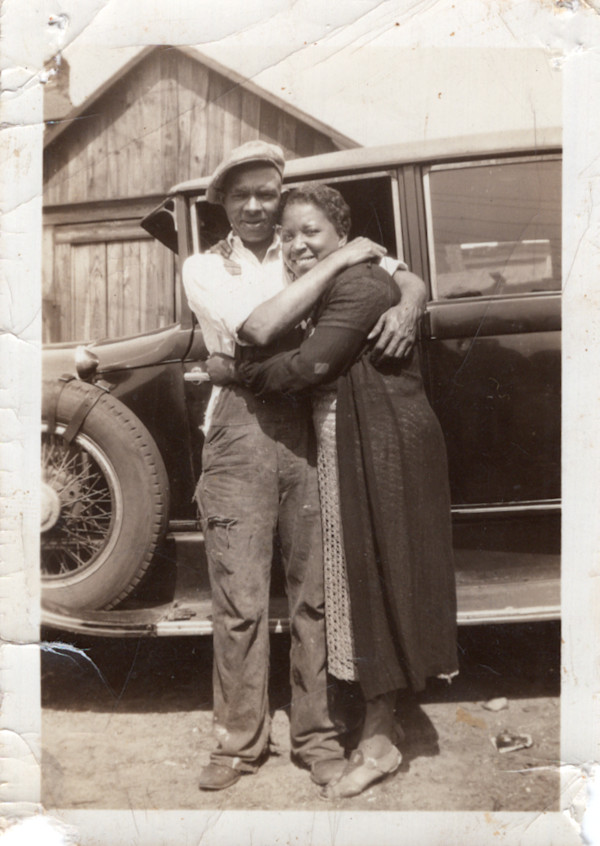 Couple embracing next to automobile by Unknown