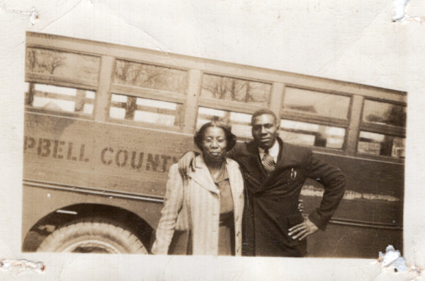 Couple standing next to Campbell County bus by Unknown