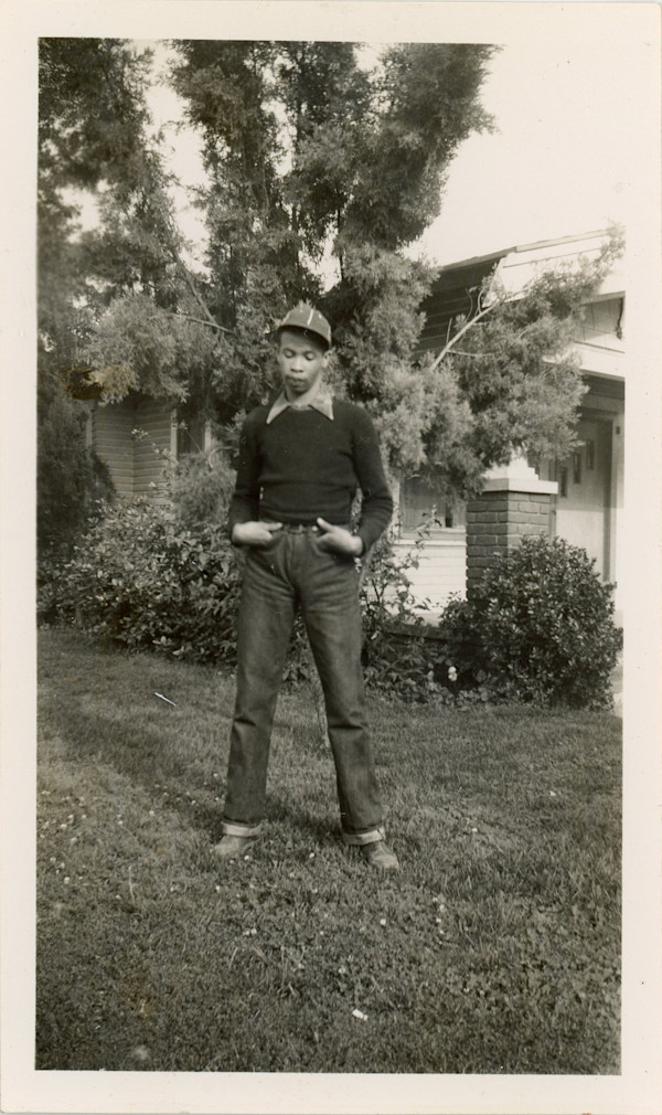 Young man in dungarees and cap by Unknown