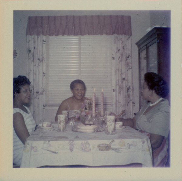 Three women at dining table by Unknown