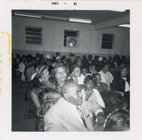 Woman with skeptical expression in audience by Unknown