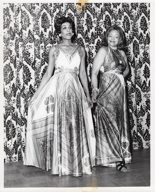 Two women modeling dresses by Unknown
