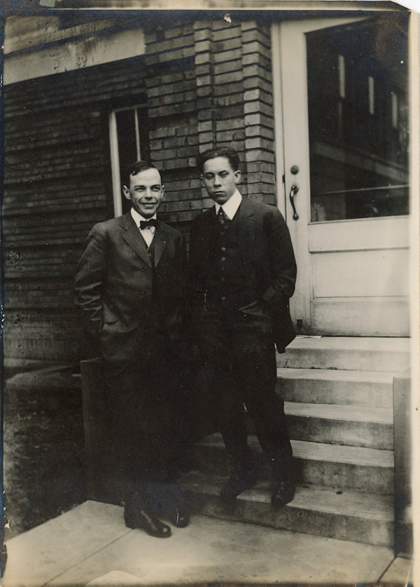 Well-dressed father and son standing at foot of steps by Unknown
